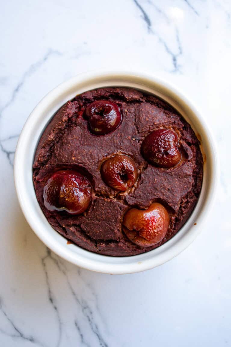 Rich chocolate cherry cobbler dessert topped with fresh cherries in a cozy white ramekin, perfect for homemade fruit desserts and easy baking recipes.