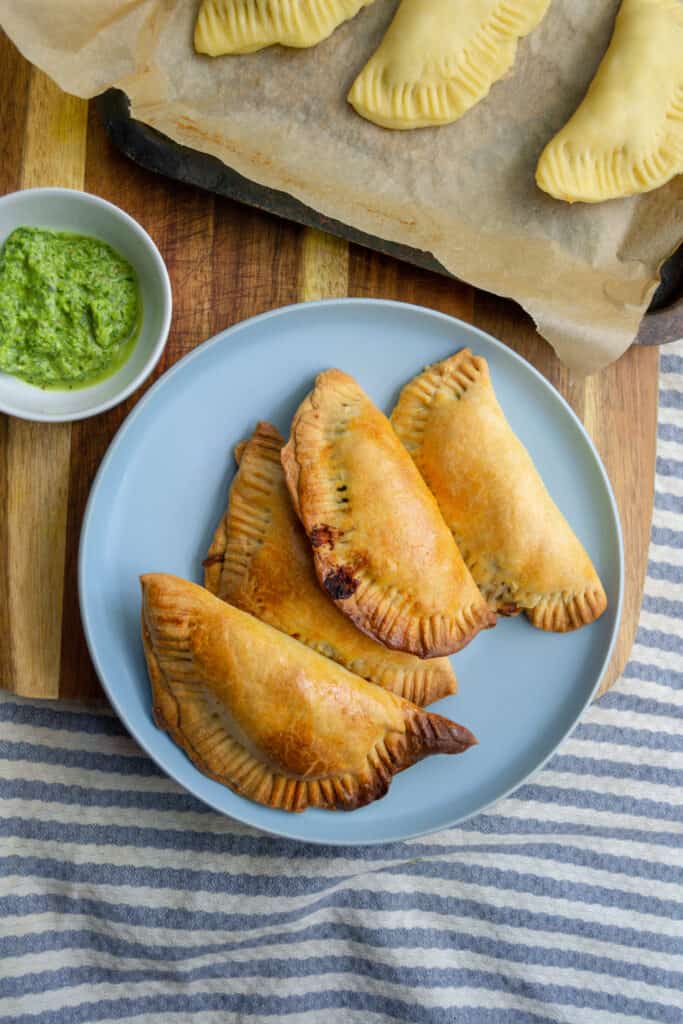 vegetarian empanadas on a plate with chimicurri