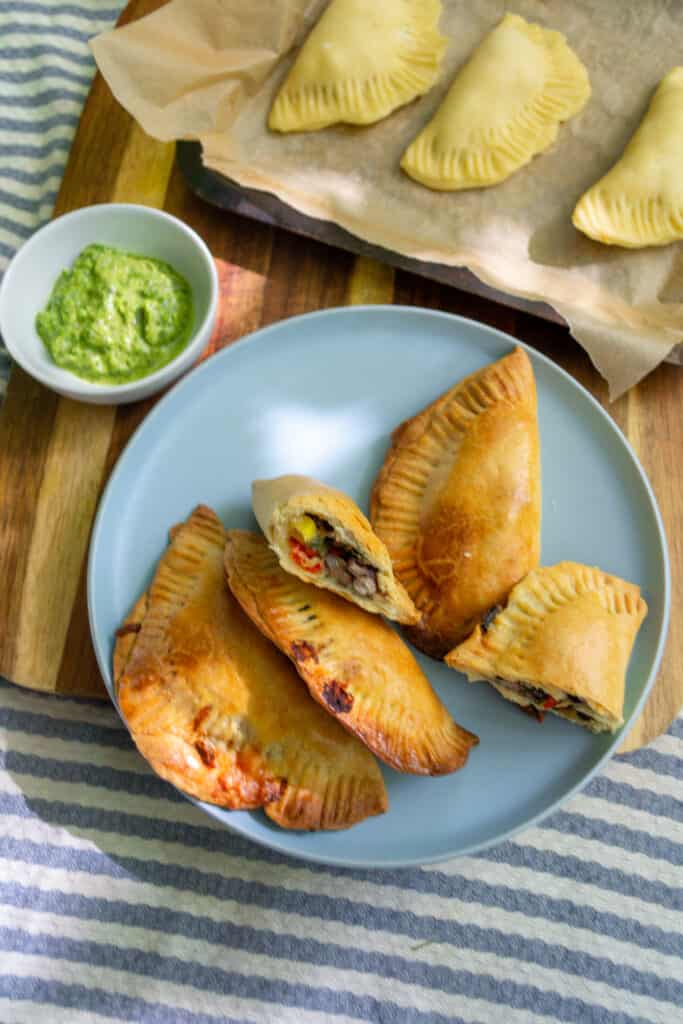 vegetarian empanadas on a plate with chimicurri sauce