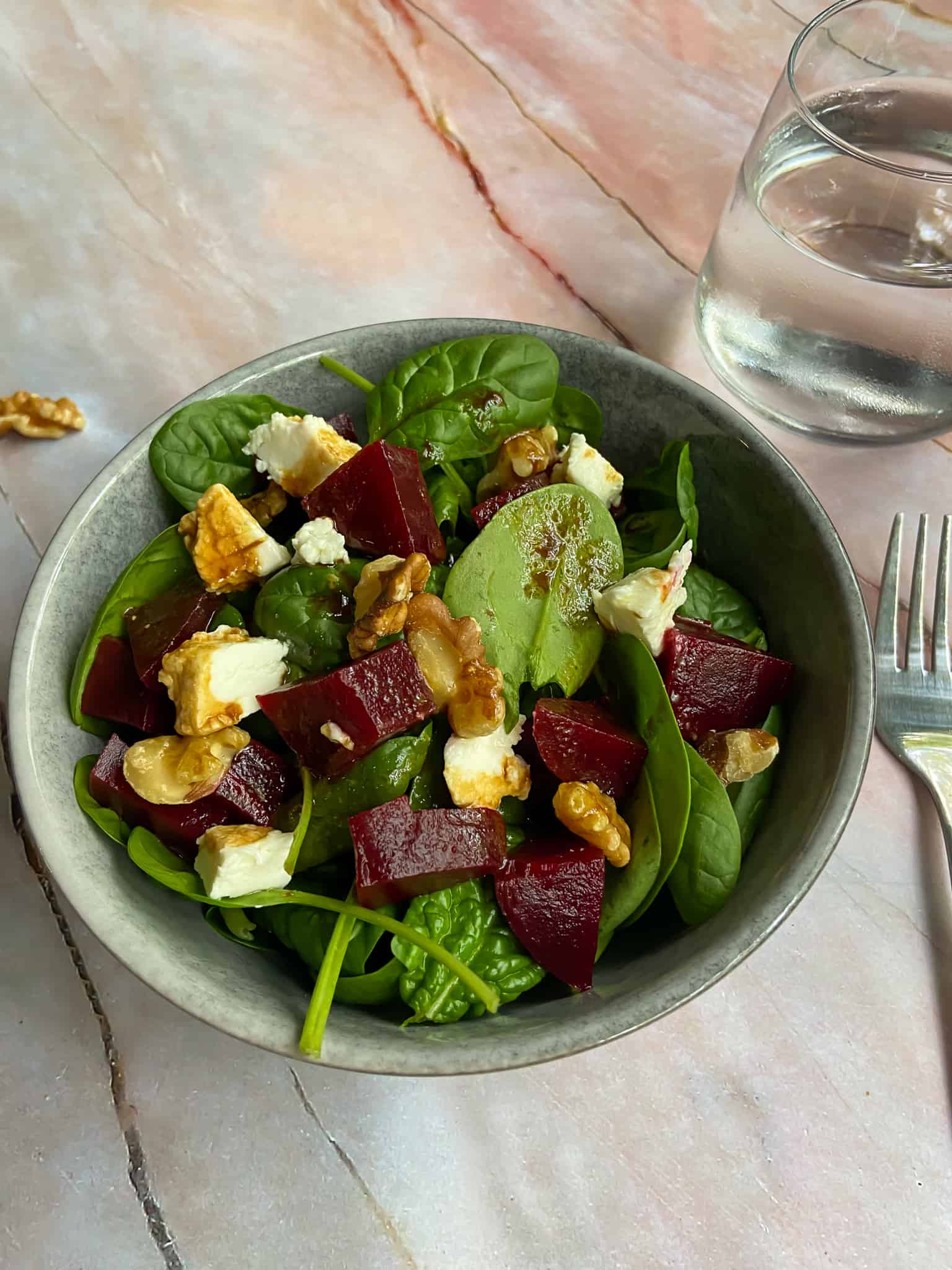 beetroot goat cheese salad with fork and water on the table