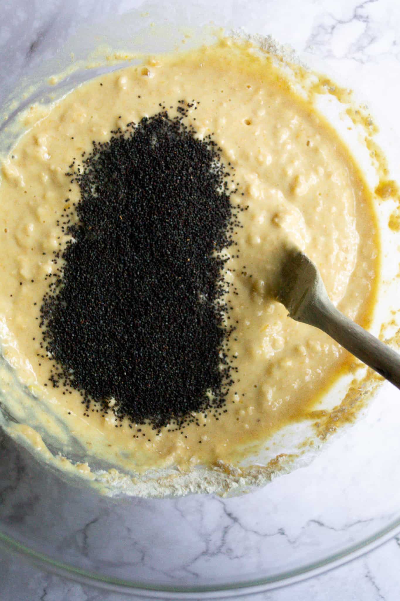 Bread batter in a bowl with poppyseeds.
