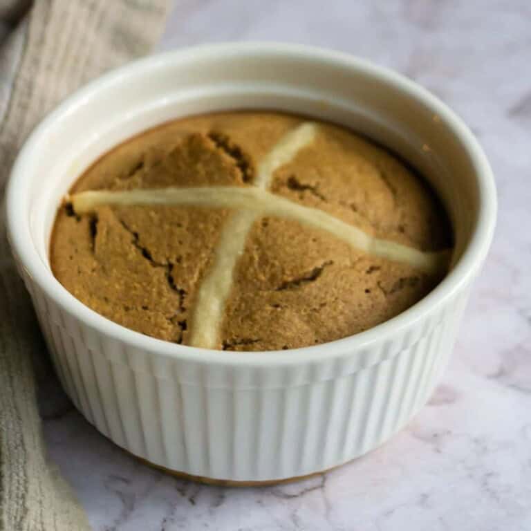 Gooey peanut butter cookie in a white ramekin, fresh baked, with a soft and chewy texture, perfect for snack or dessert, on a rustic marble surface.