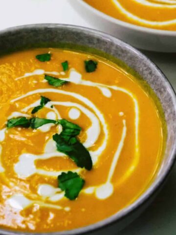 Pumpkin soup in a bowl with coconut milk.