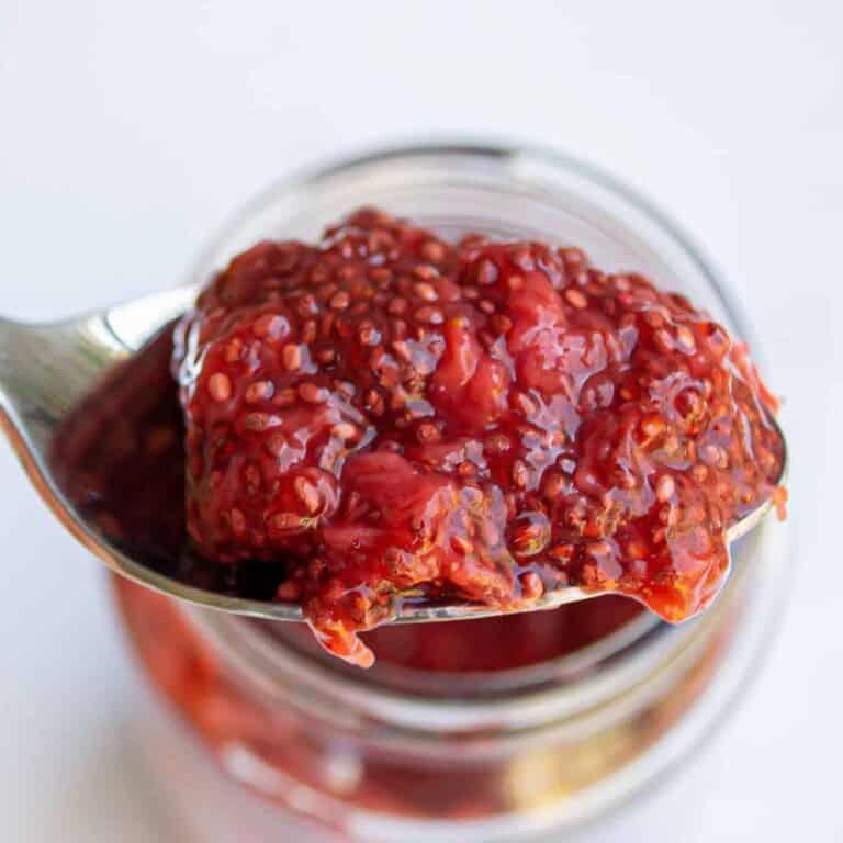 Creamy red chili pepper jelly spread in a glass jar, ready to use for cooking, glazing, or as a condiment. Perfect for adding a spicy-sweet flavor to your favorite dishes.