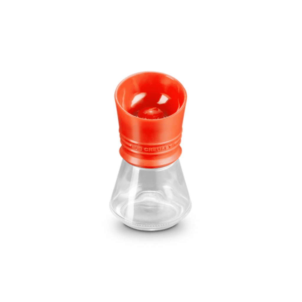 Le Creuset spice grinder, glass with an orange lid.