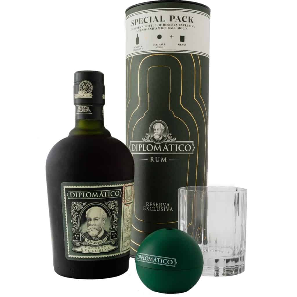 Diplomatico rum bottle next to special gift cannister, rocks glass and spherical ice mould.