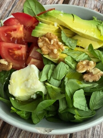 A thumbnail image of a spinach, avocado and tomato salad.