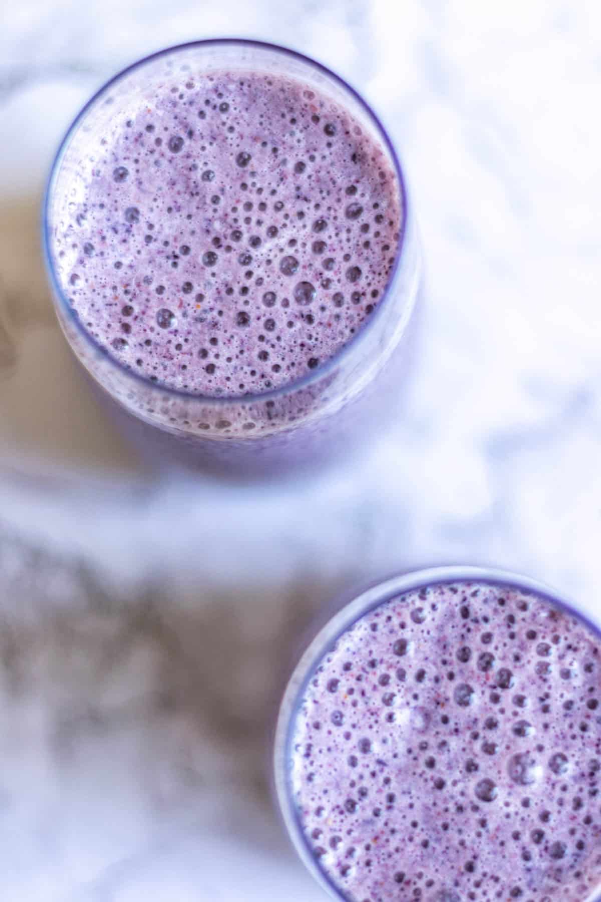 Overhead shot of two glasses of cherry berry smoothie.