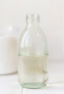Up close image of simple syrup in a glass bottle.