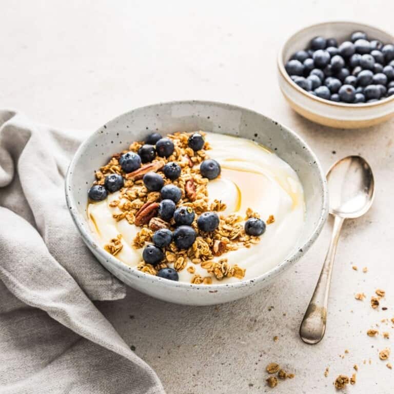Fresh blueberry yogurt parfait with granola and honey, served in a rustic bowl. Perfect for a healthy breakfast or snack, featuring fresh blueberries, crunchy granola, and creamy yogurt.