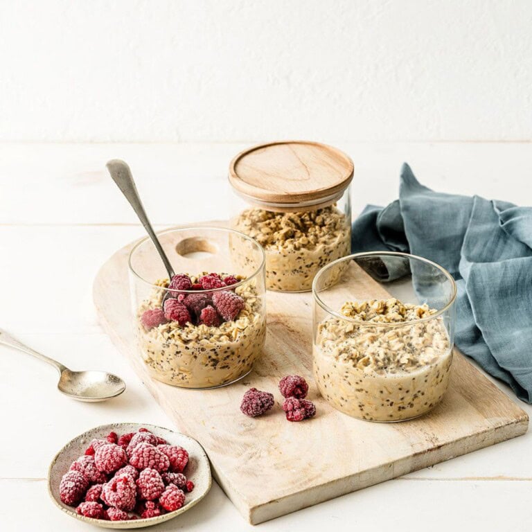 Creamy overnight oats with fresh raspberries and granola in glass bowls for healthy breakfast ideas. Simple, delicious, and nutritious oatmeal parfaits with berries and nuts.