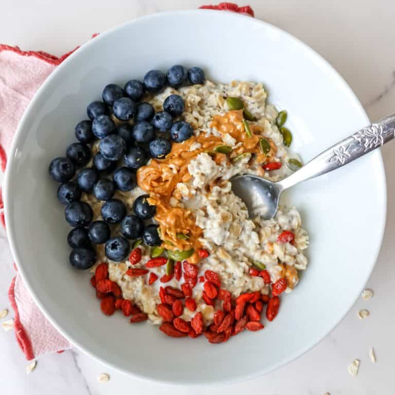 Blueberries, oatmeal, chia seeds, goji berries, pumpkin seeds, healthy breakfast bowl with oatmeal and fresh berries, nutritious vegan breakfast options.