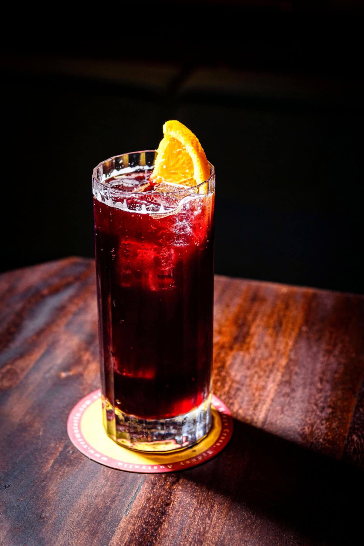 Kalimoxto cocktail in a highball glass, served with an orange.
