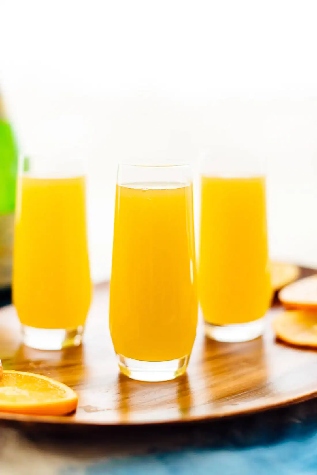 Three mimosas served in stemless champagne flutes.