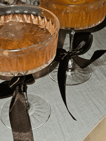 New Year's party champagne cocktails in fancy glasses with black ribbons around the stem.